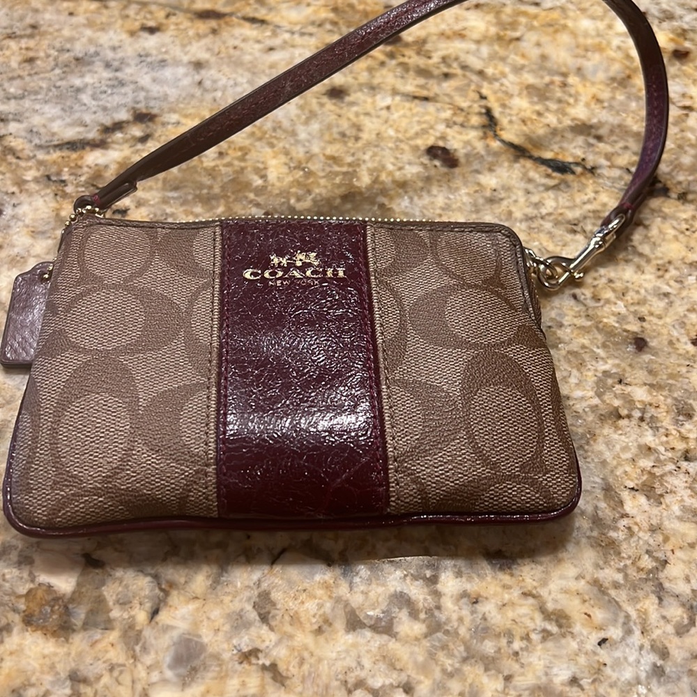 Coach wristlet wallet. Dark brown maroon leather and Coach logo design.
